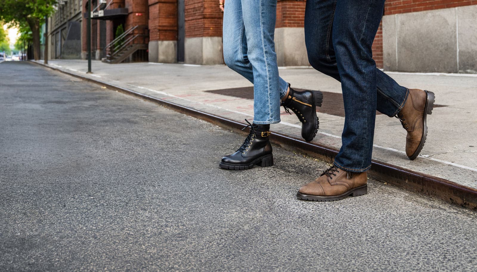Two people walking down a city street in leather boots